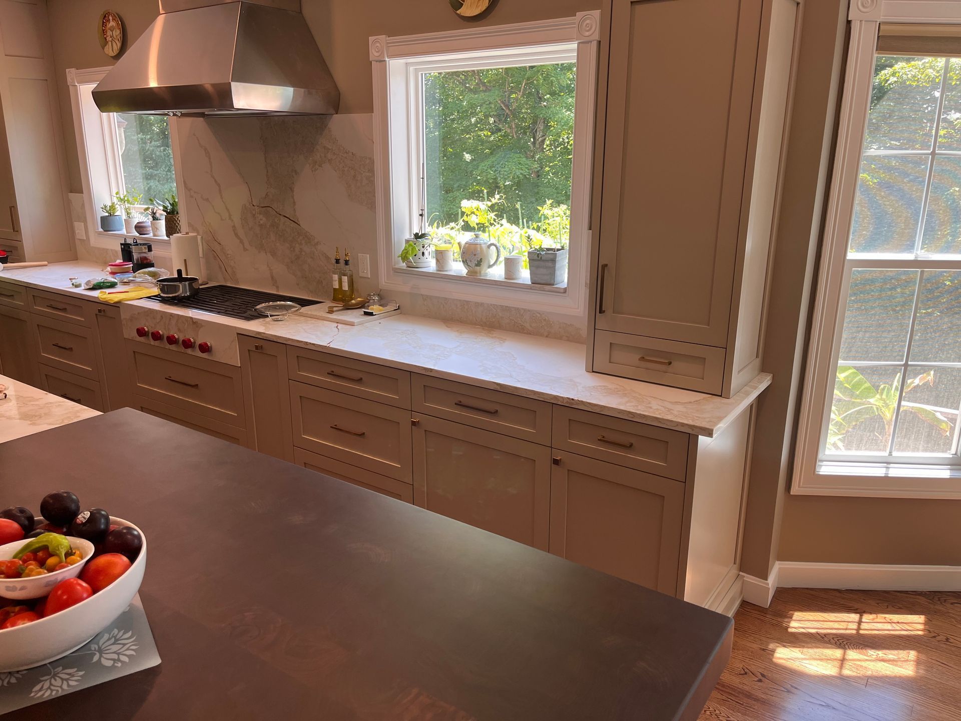 A kitchen with a bowl of fruit on the counter and a window.