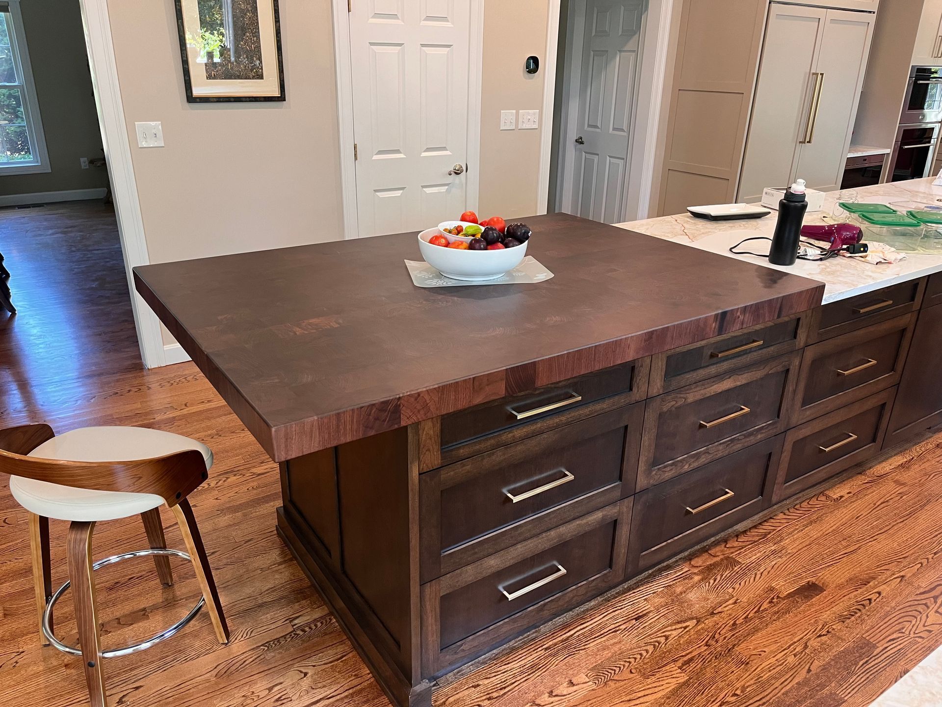 A kitchen island with a bowl of fruit on top of it.