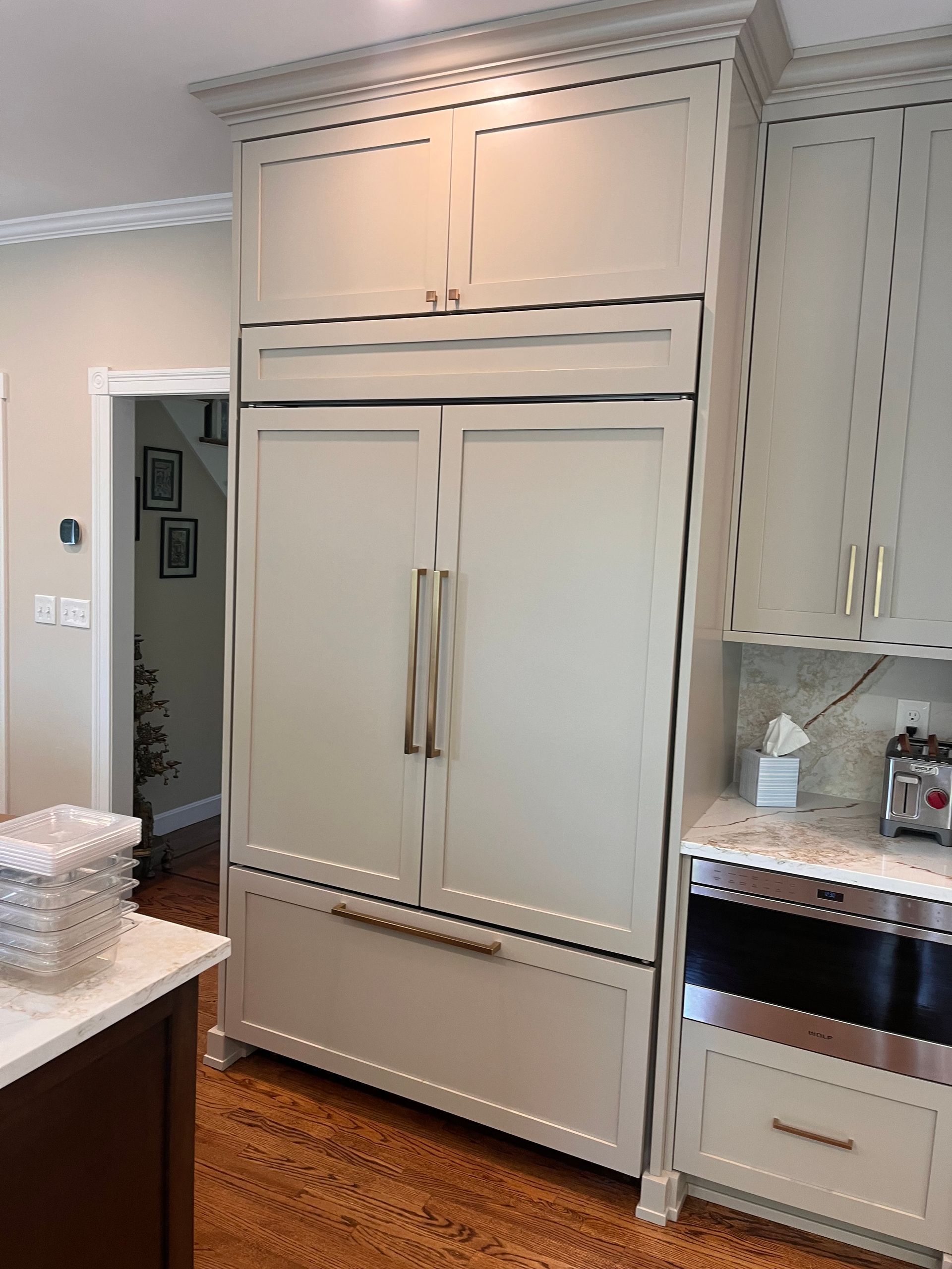 A kitchen with white cabinets and a large refrigerator freezer.