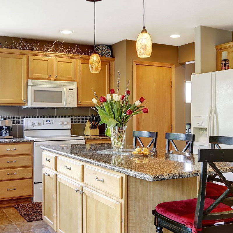 A kitchen with a vase of flowers on the counter