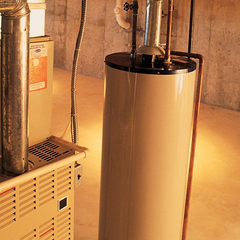 A water heater in a basement next to a furnace