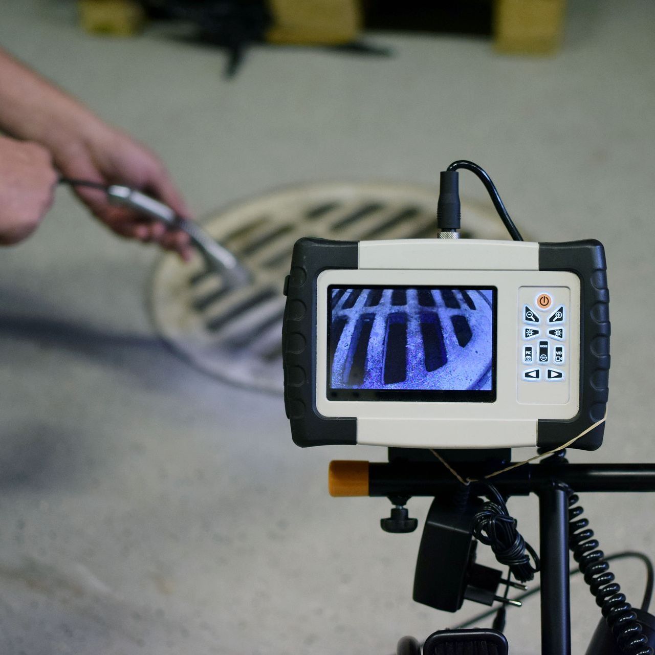 A person is holding a thermal camera in front of a house