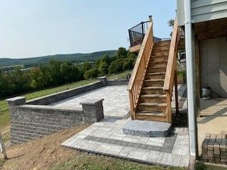 A wooden staircase leading up to a patio with a deck