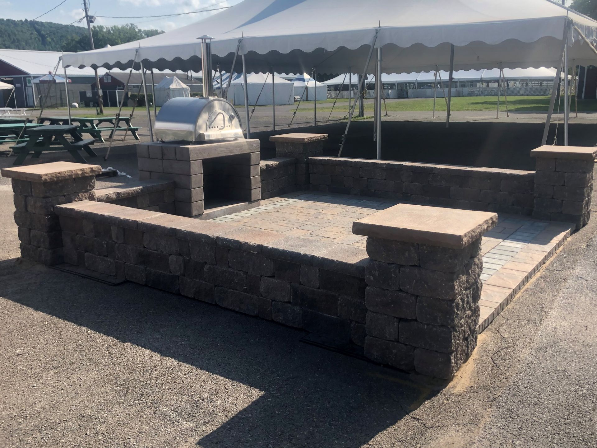 A brick wall with a grill and a tent in the background