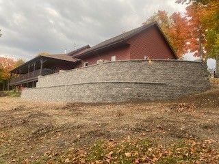 A large house with a large stone wall in front of it