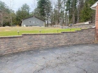 A brick wall surrounds a driveway 