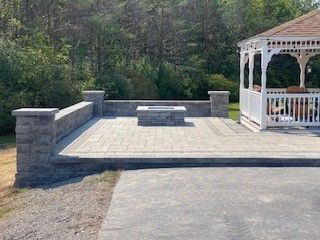 A gazebo with a fire pit in the middle of it