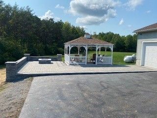 A gazebo is sitting in the middle of a driveway