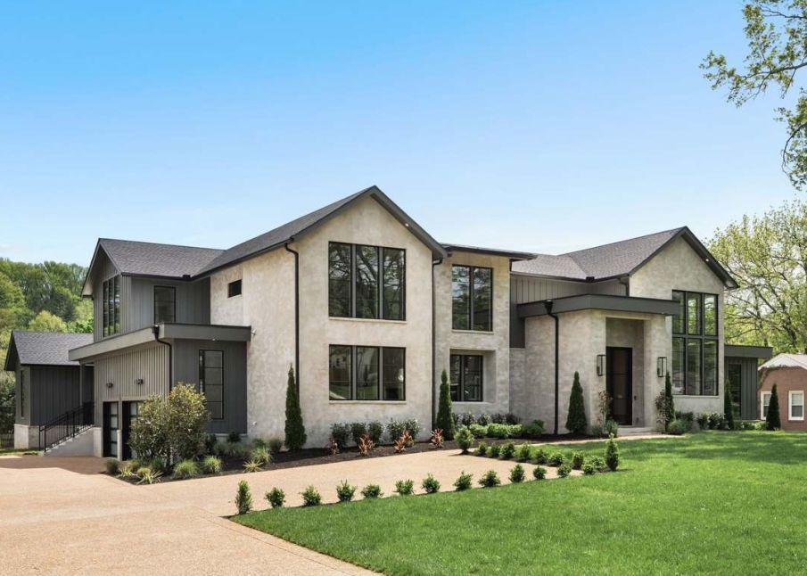 A large white house with a lush green lawn in front of it.