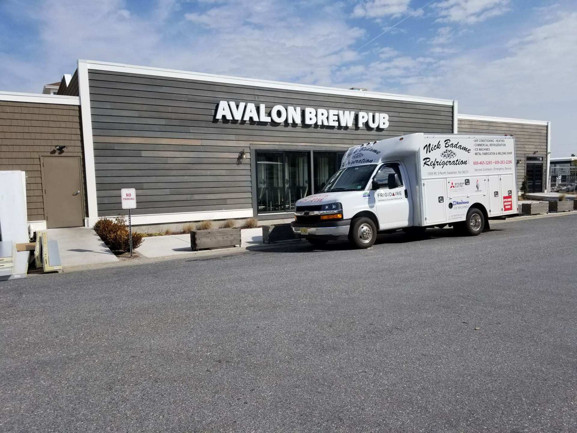 Avalon Brew Pub storefront with a white delivery van parked outside on a gravel lot.
