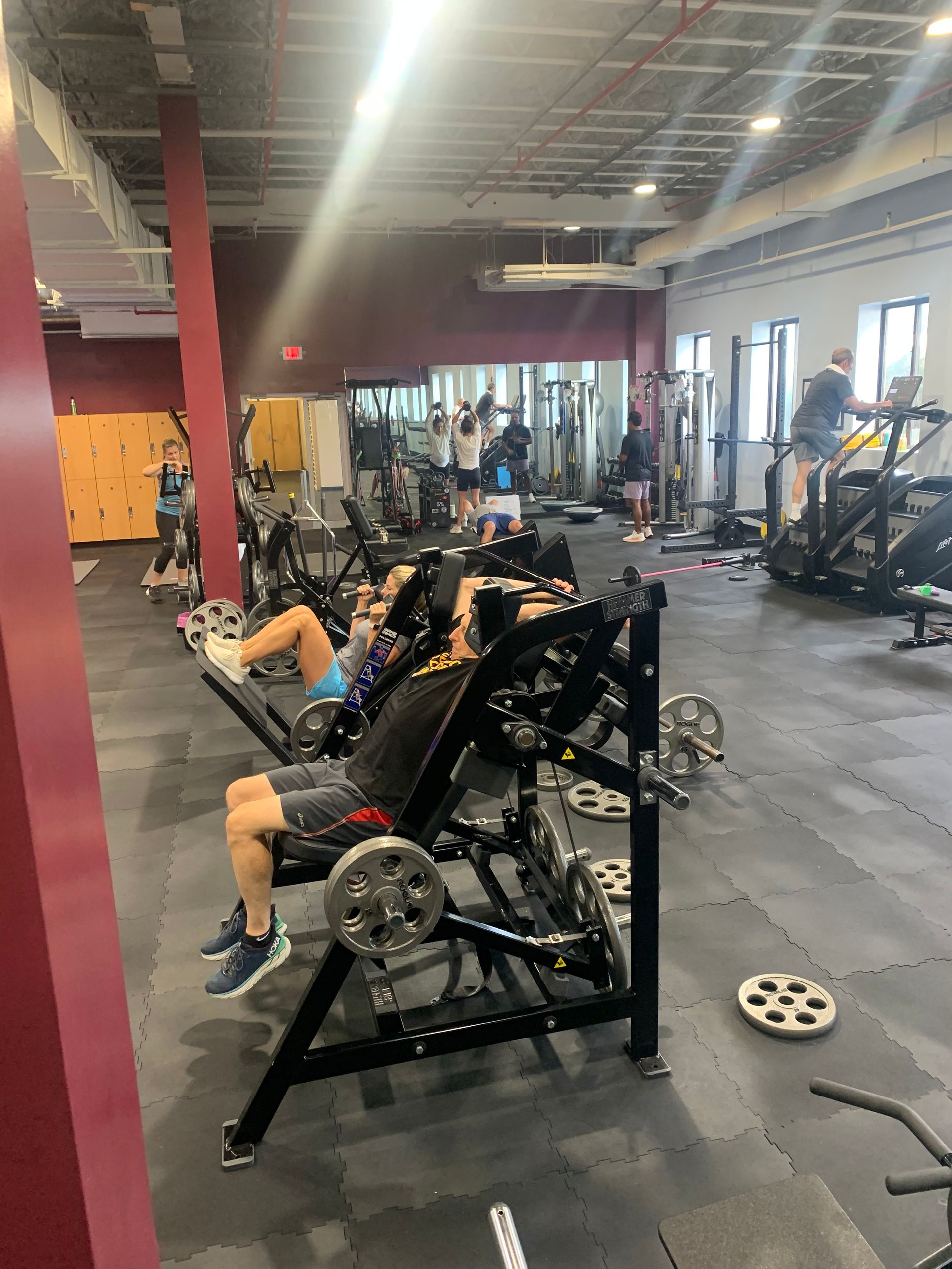A man is sitting on a bench in a gym.