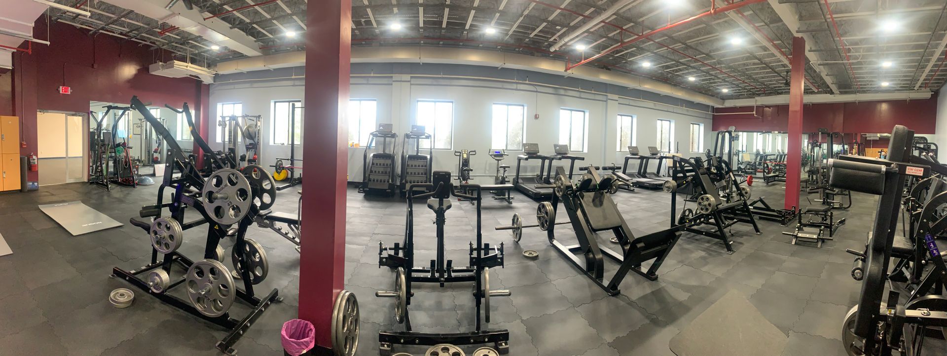 A large gym filled with lots of exercise equipment.