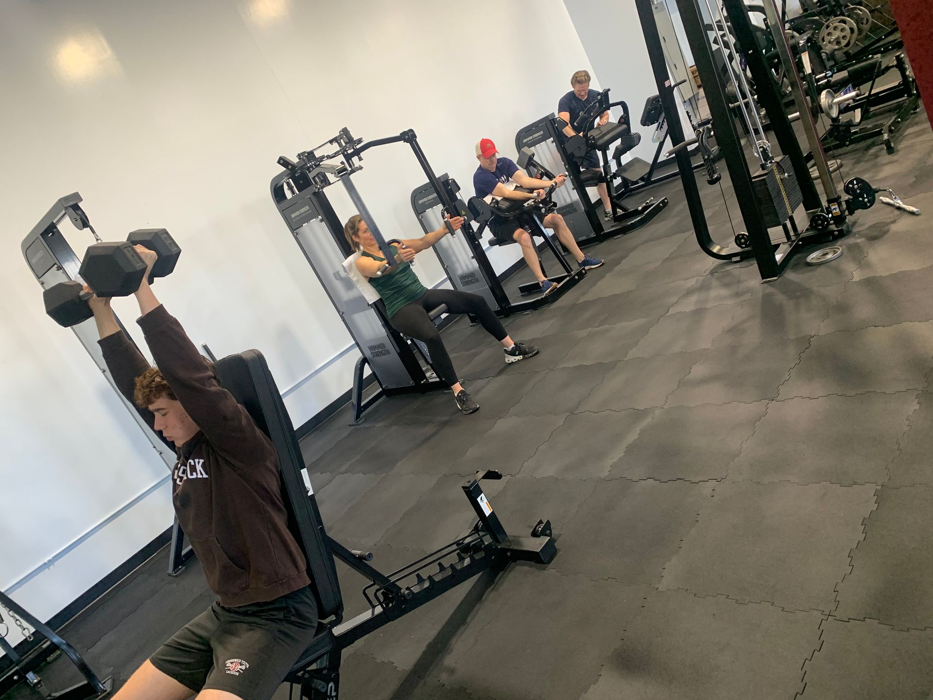A group of people are lifting dumbbells in a gym.
