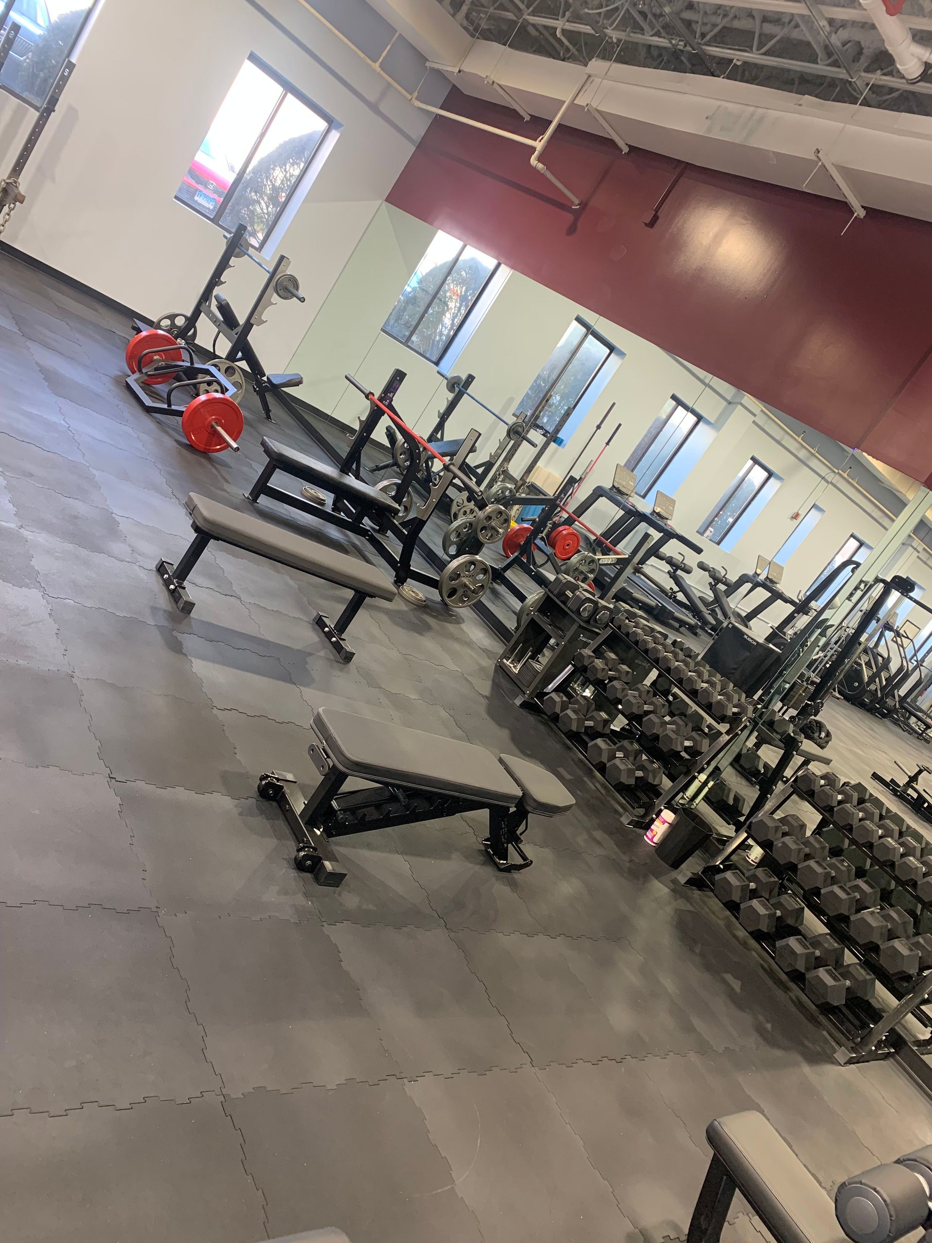 A gym filled with lots of dumbbells and benches.