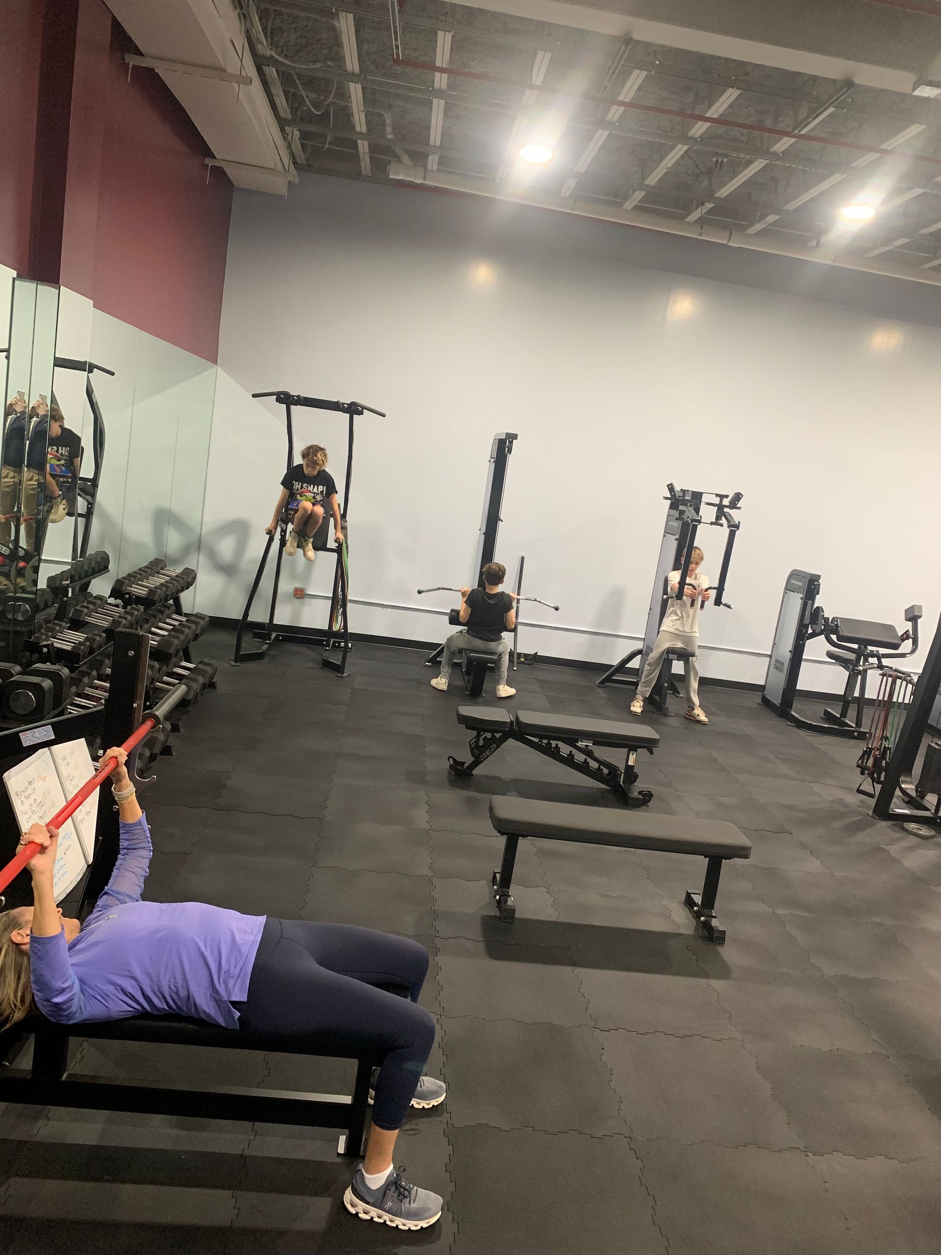 A woman is doing exercises on a bench in a gym.