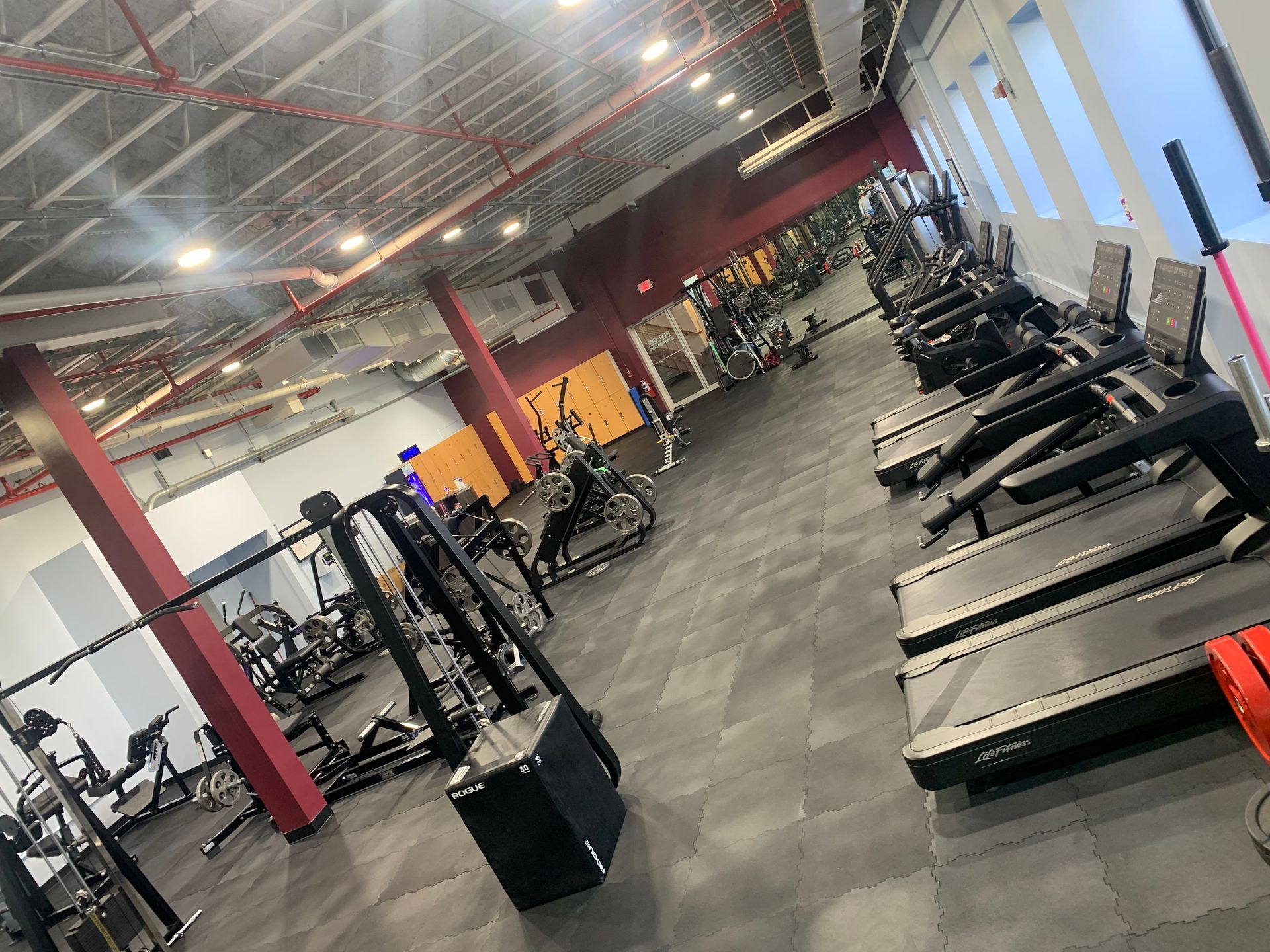 A gym filled with lots of exercise equipment and treadmills.