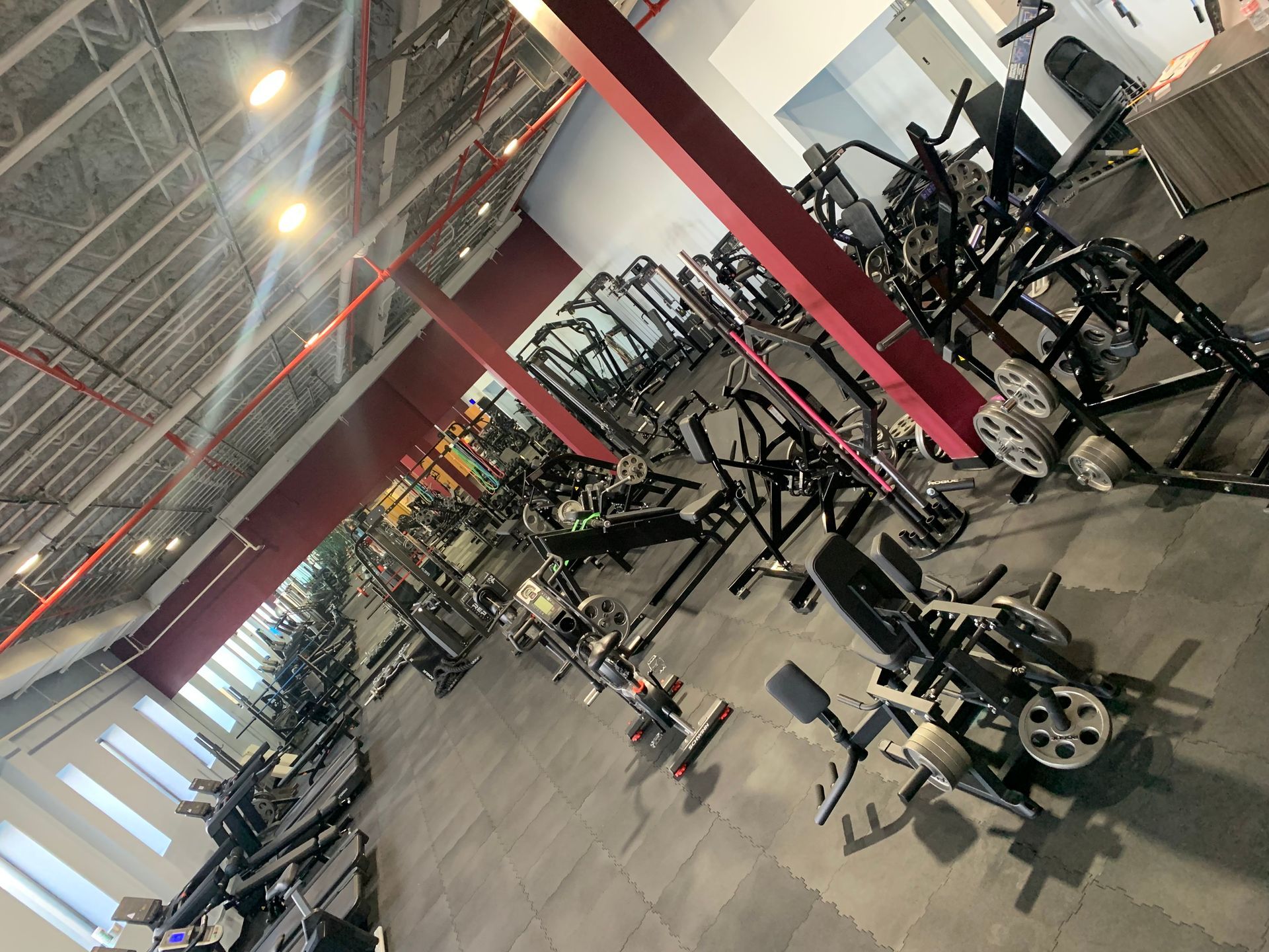 A large gym filled with lots of exercise equipment.