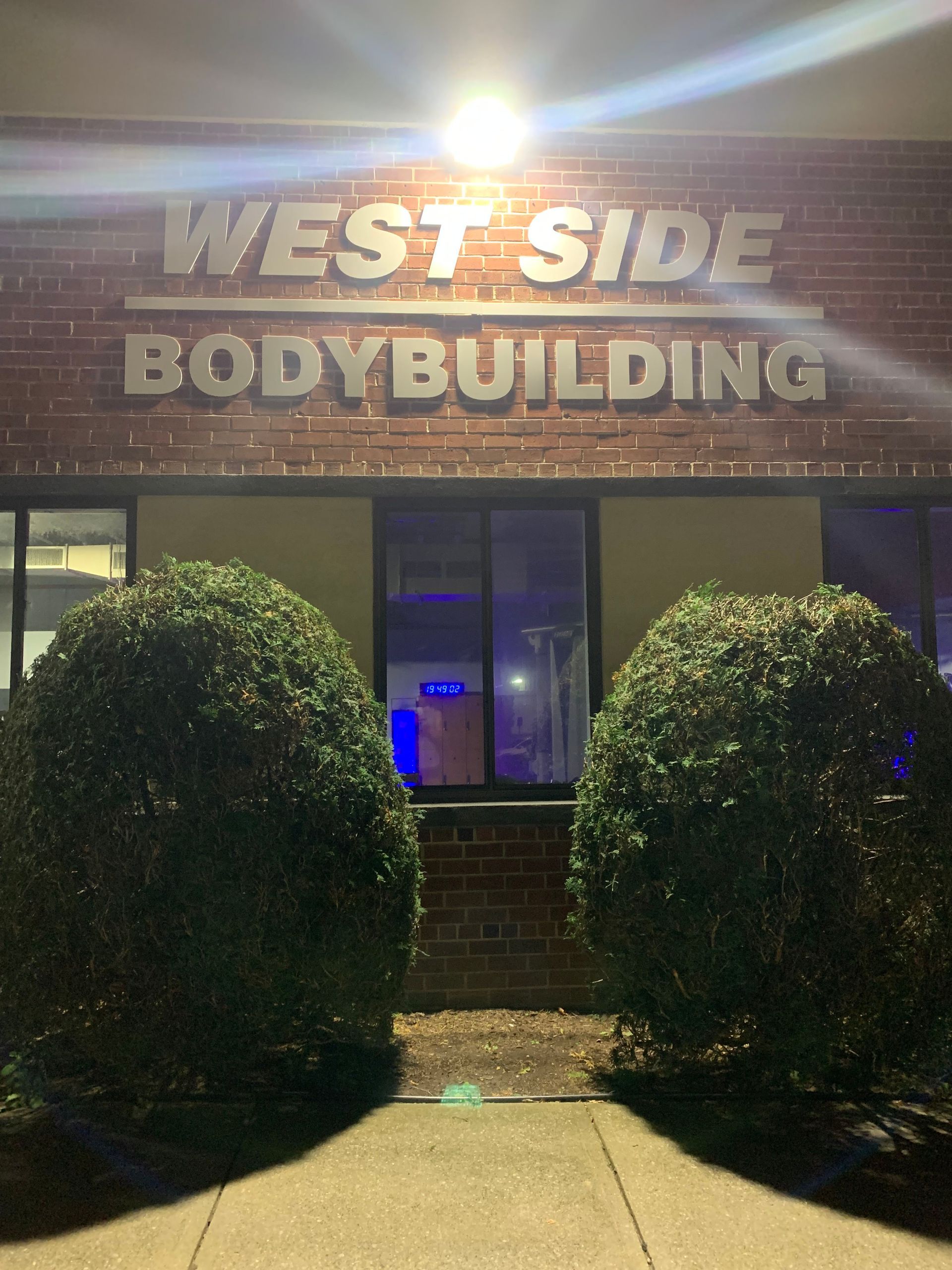 A brick building with a sign that says west side bodybuilding.