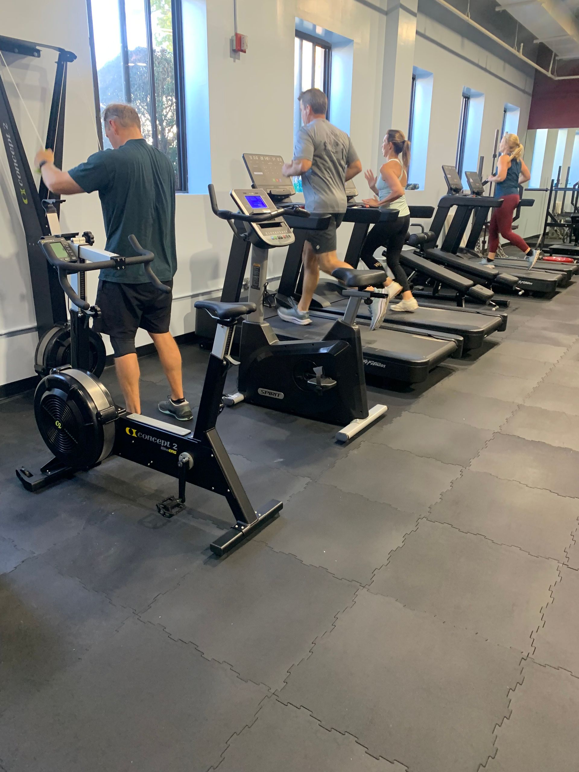 A man is riding an exercise bike in a gym.