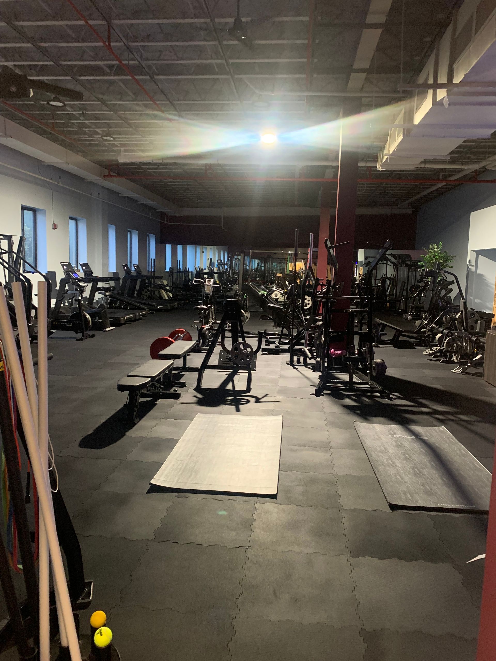 A large gym filled with lots of exercise equipment.