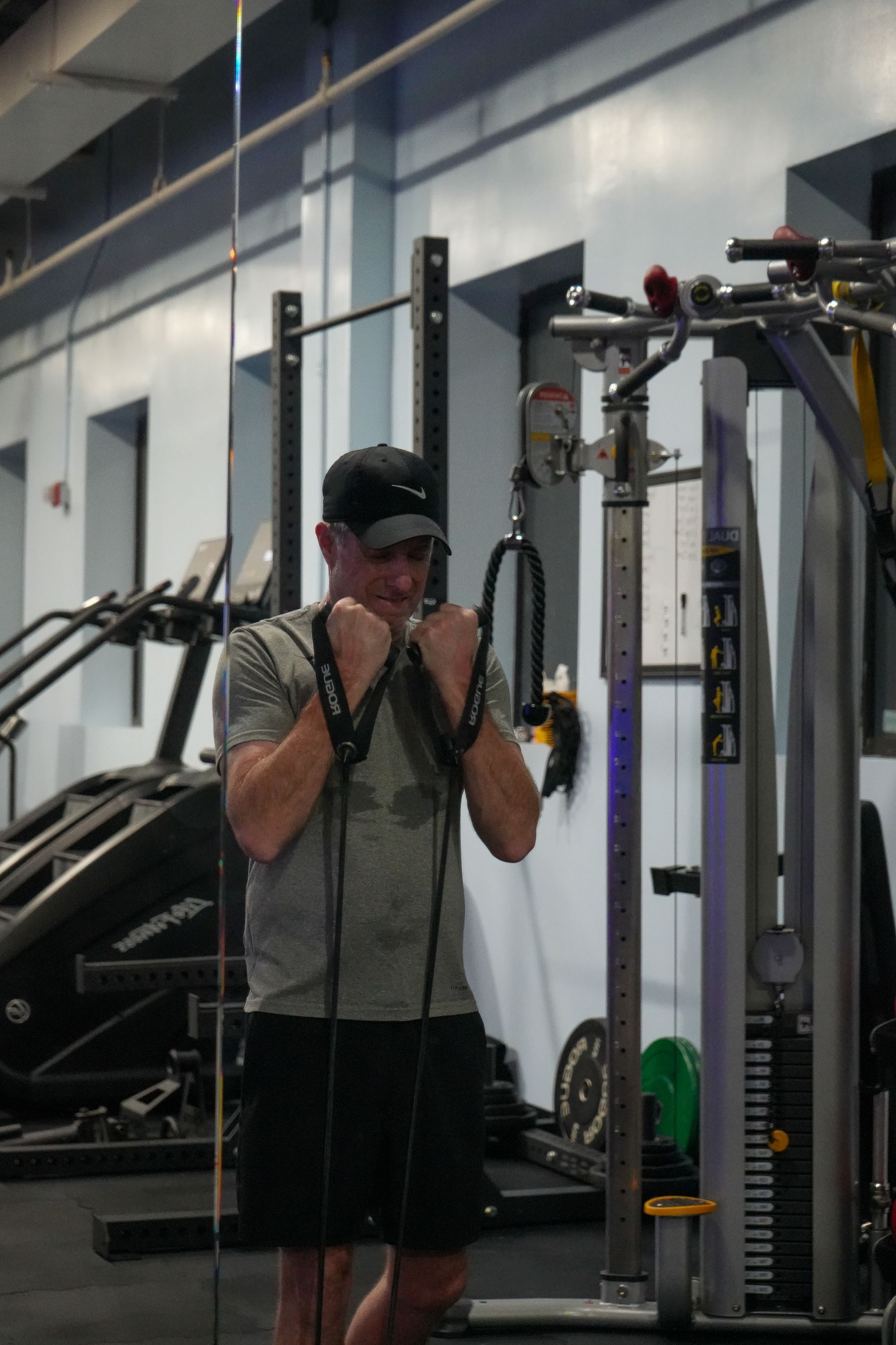 A man is standing in a gym holding a rope.