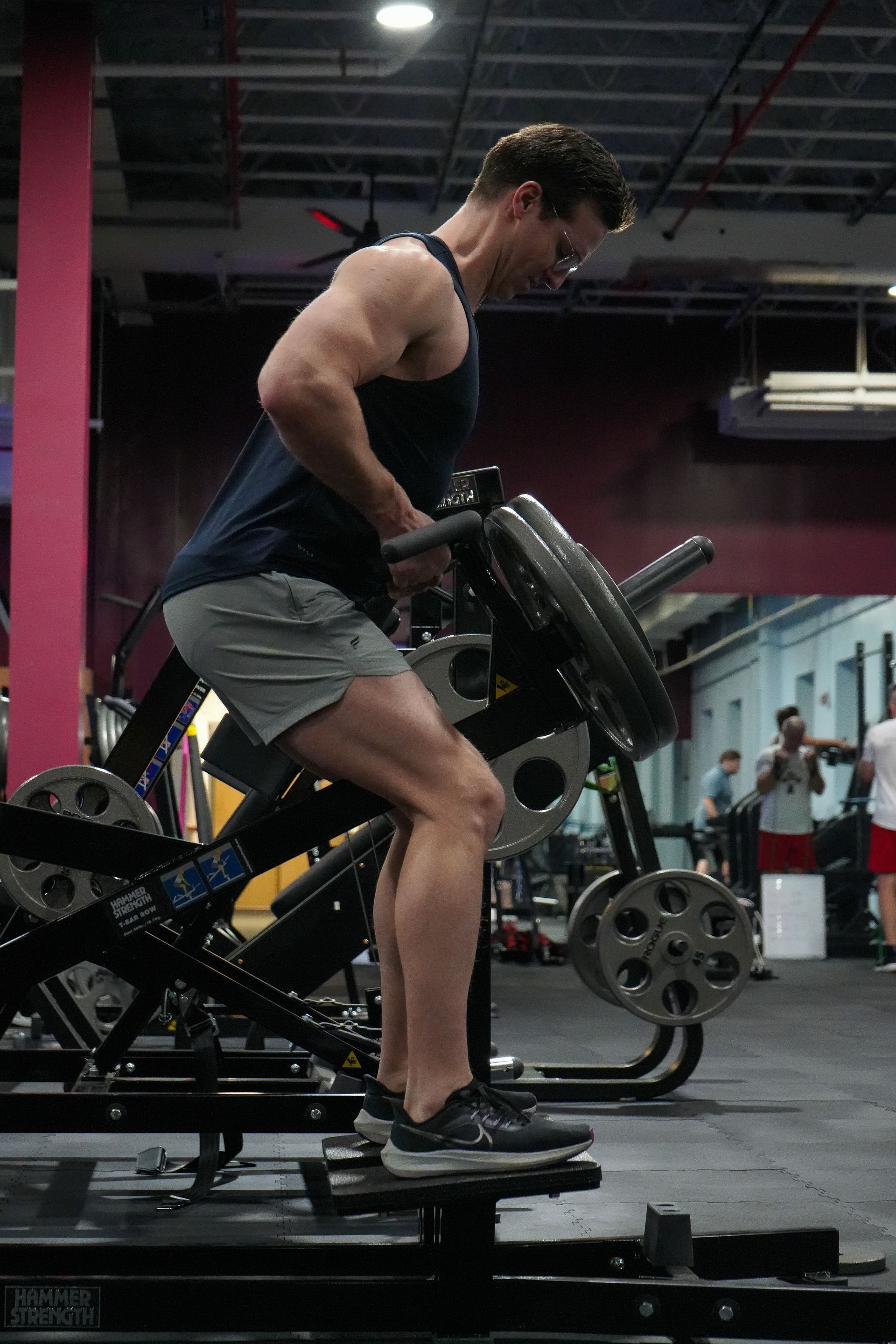 A man is standing on a machine in a gym.