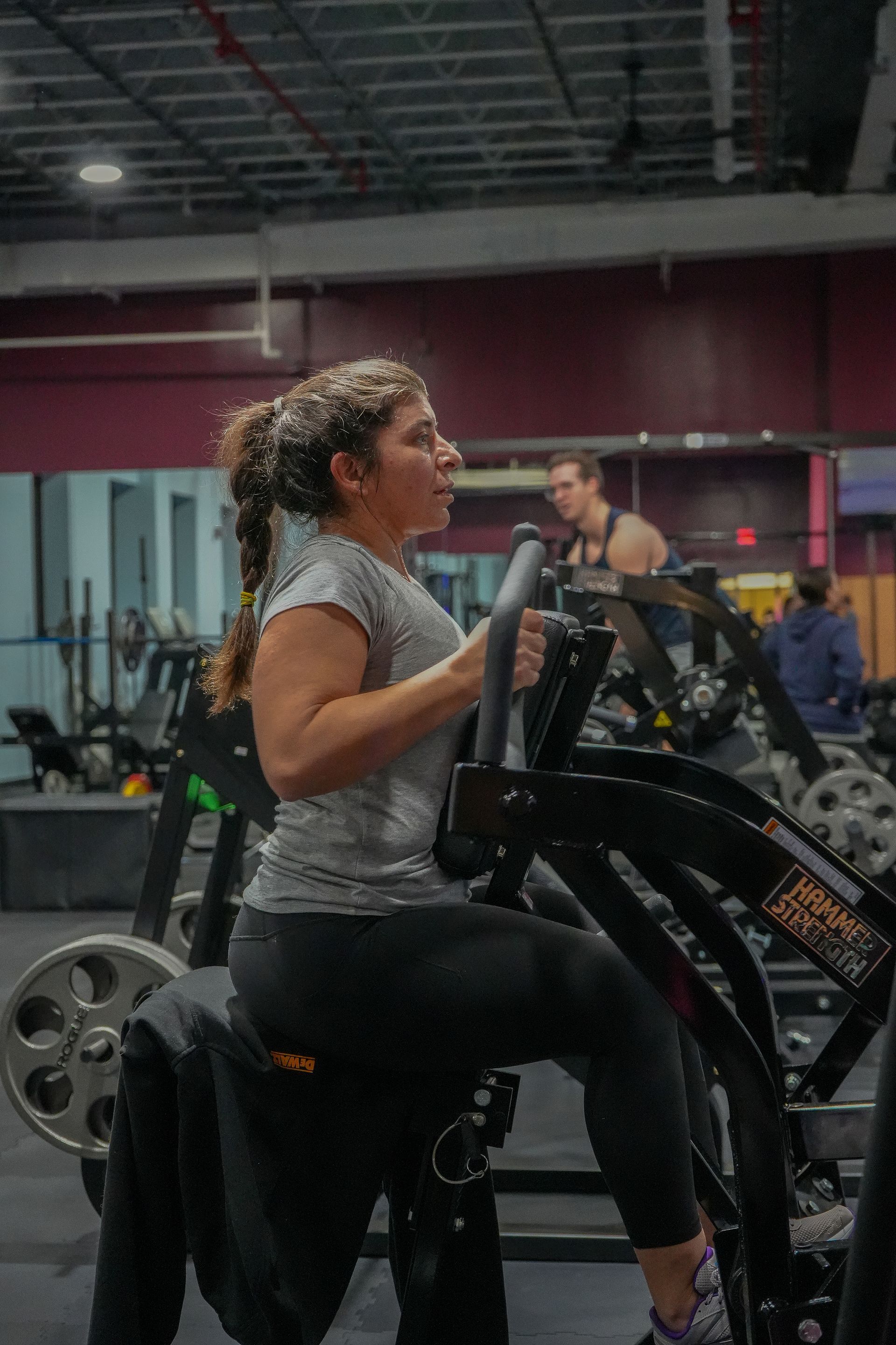 A woman is riding an exercise bike in a gym.