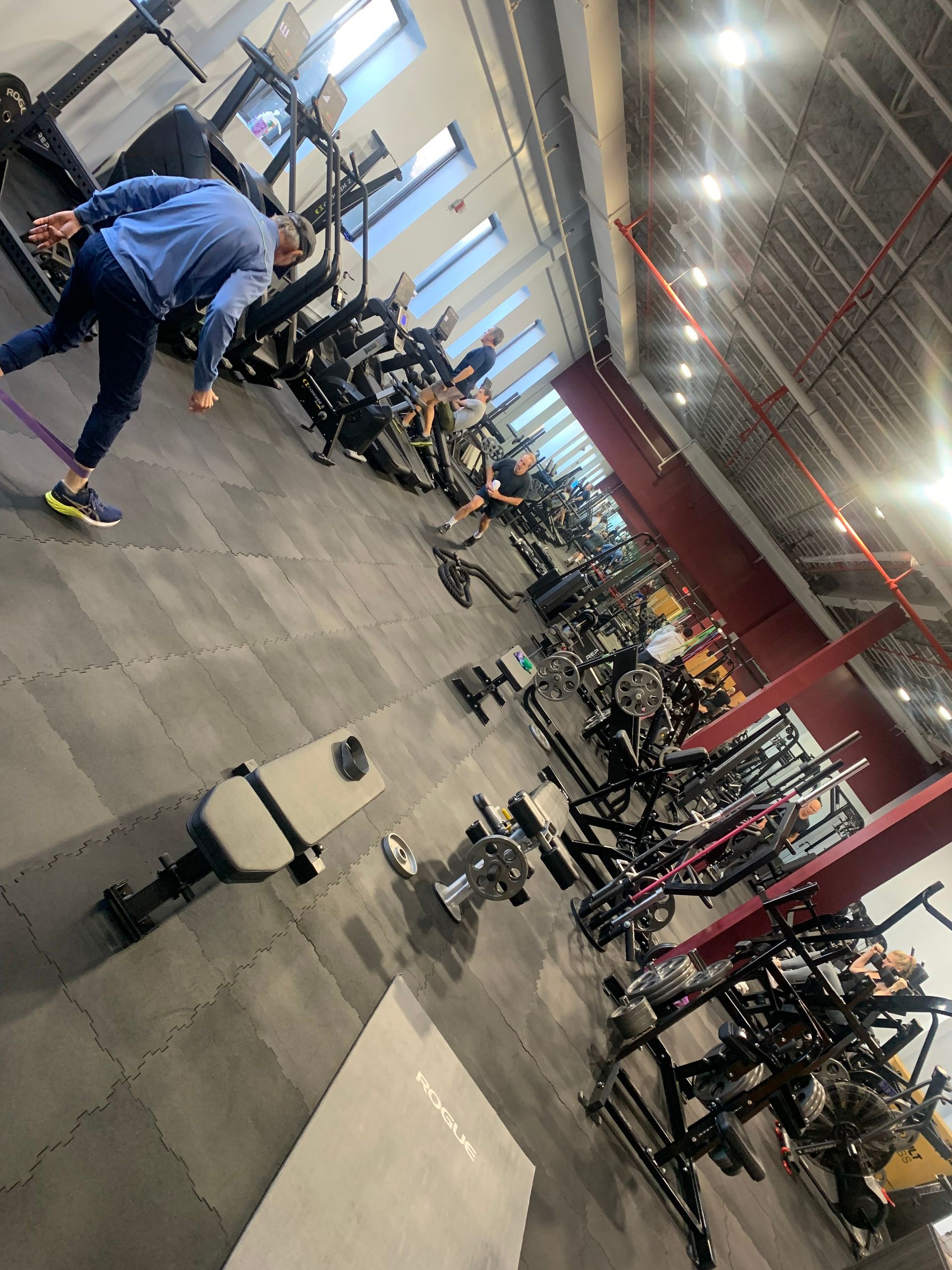 A man is doing exercises in a gym with a lot of equipment.