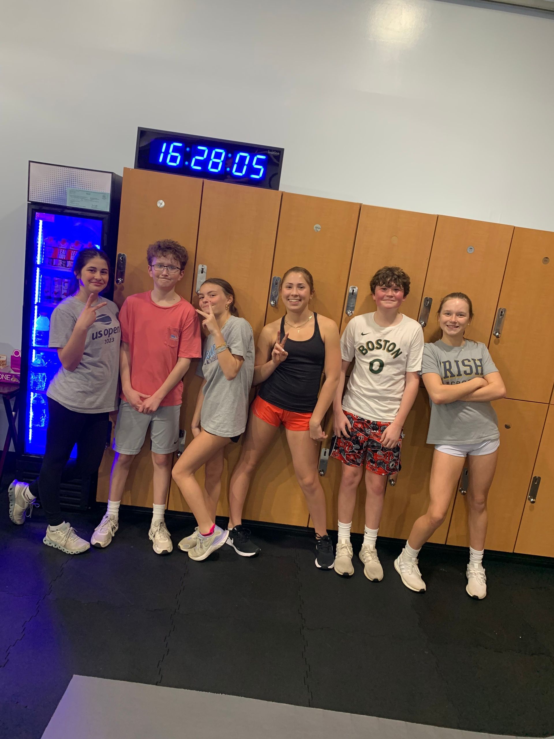 A group of young people are posing for a picture in a locker room.