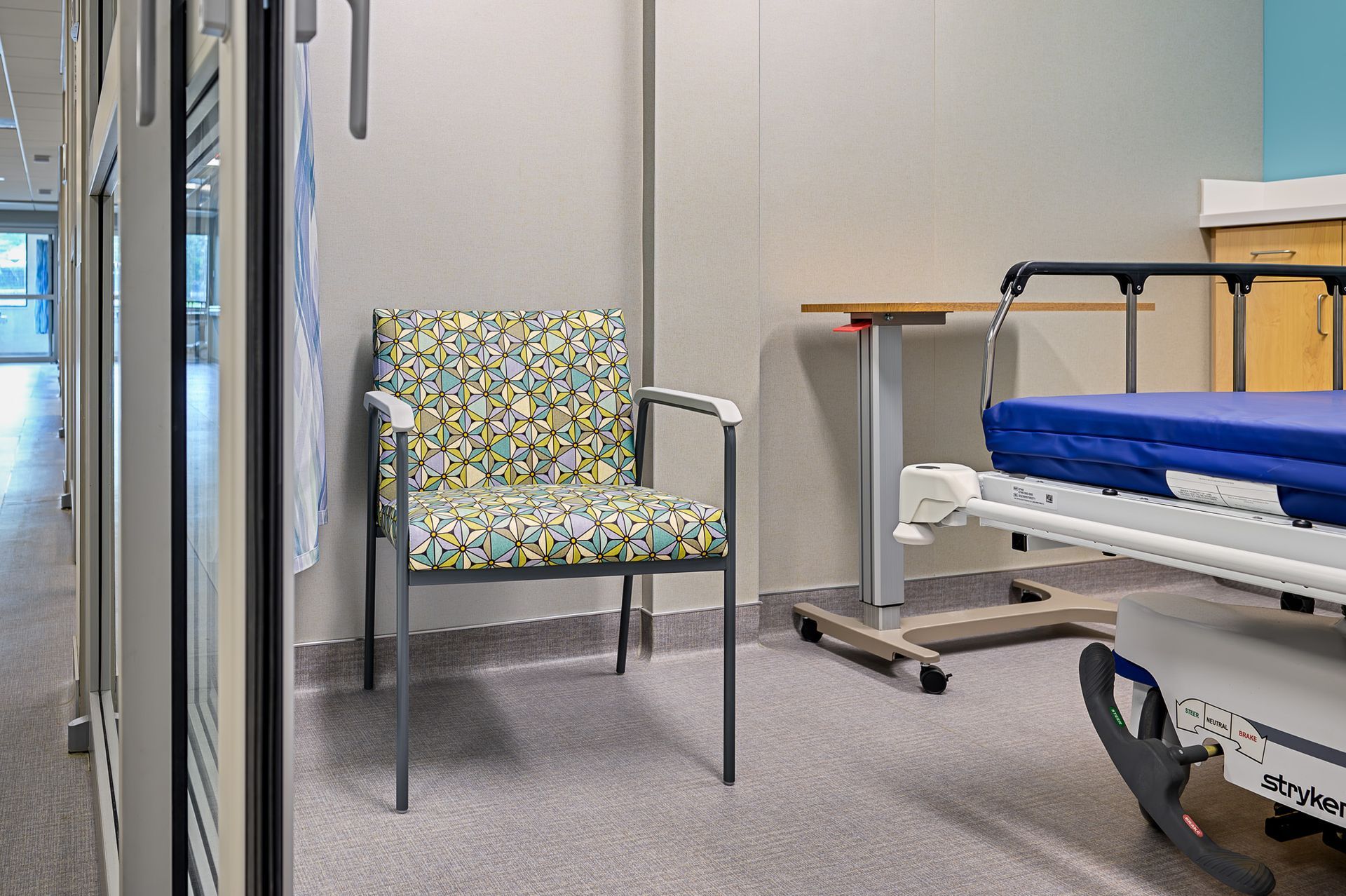 A hospital bed with a single chair 