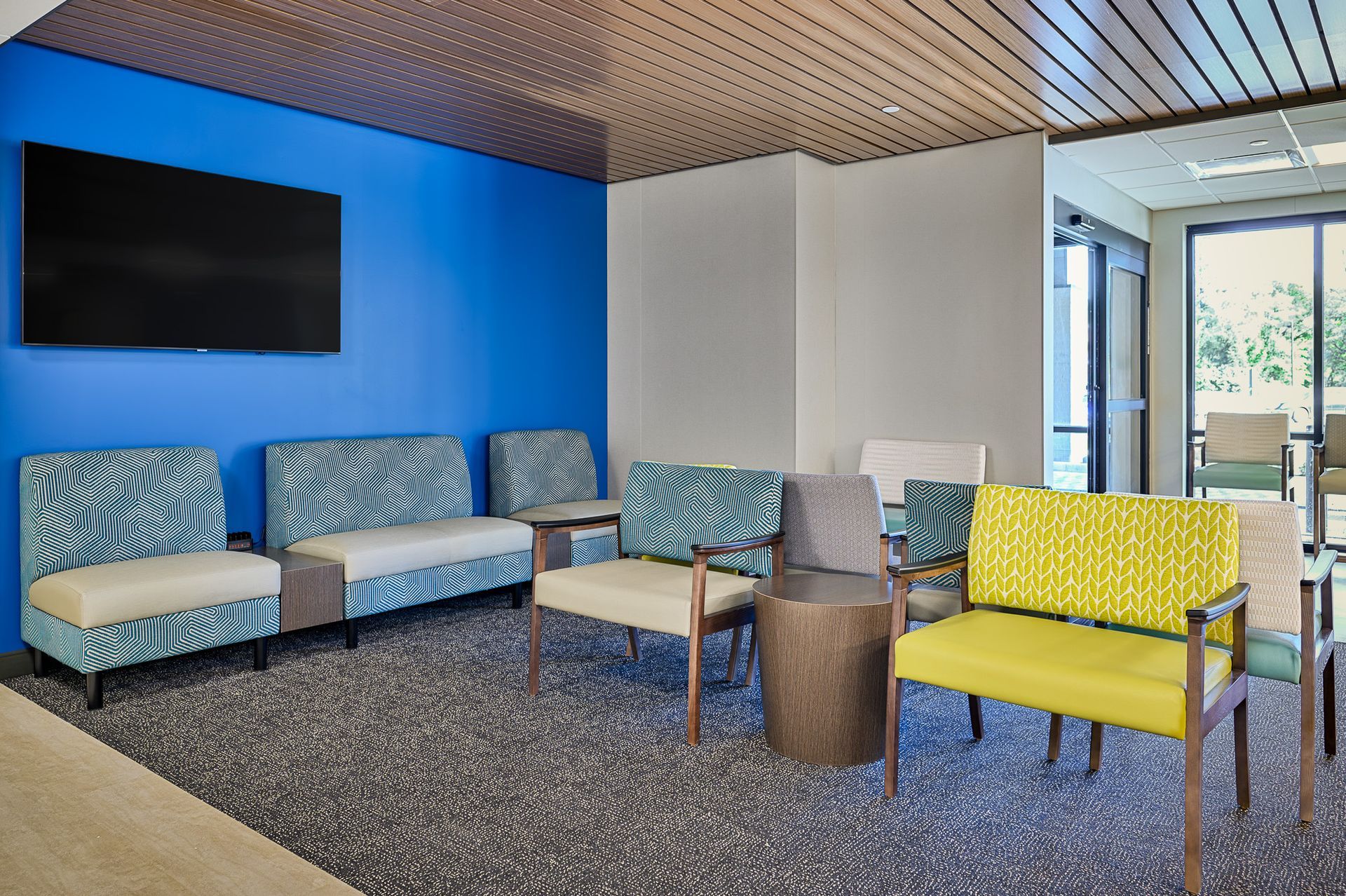 A room with chairs and a wall mounted television