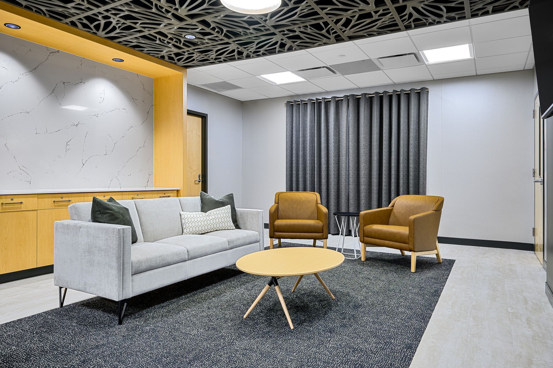 A lounge with a gray couch and wooden table