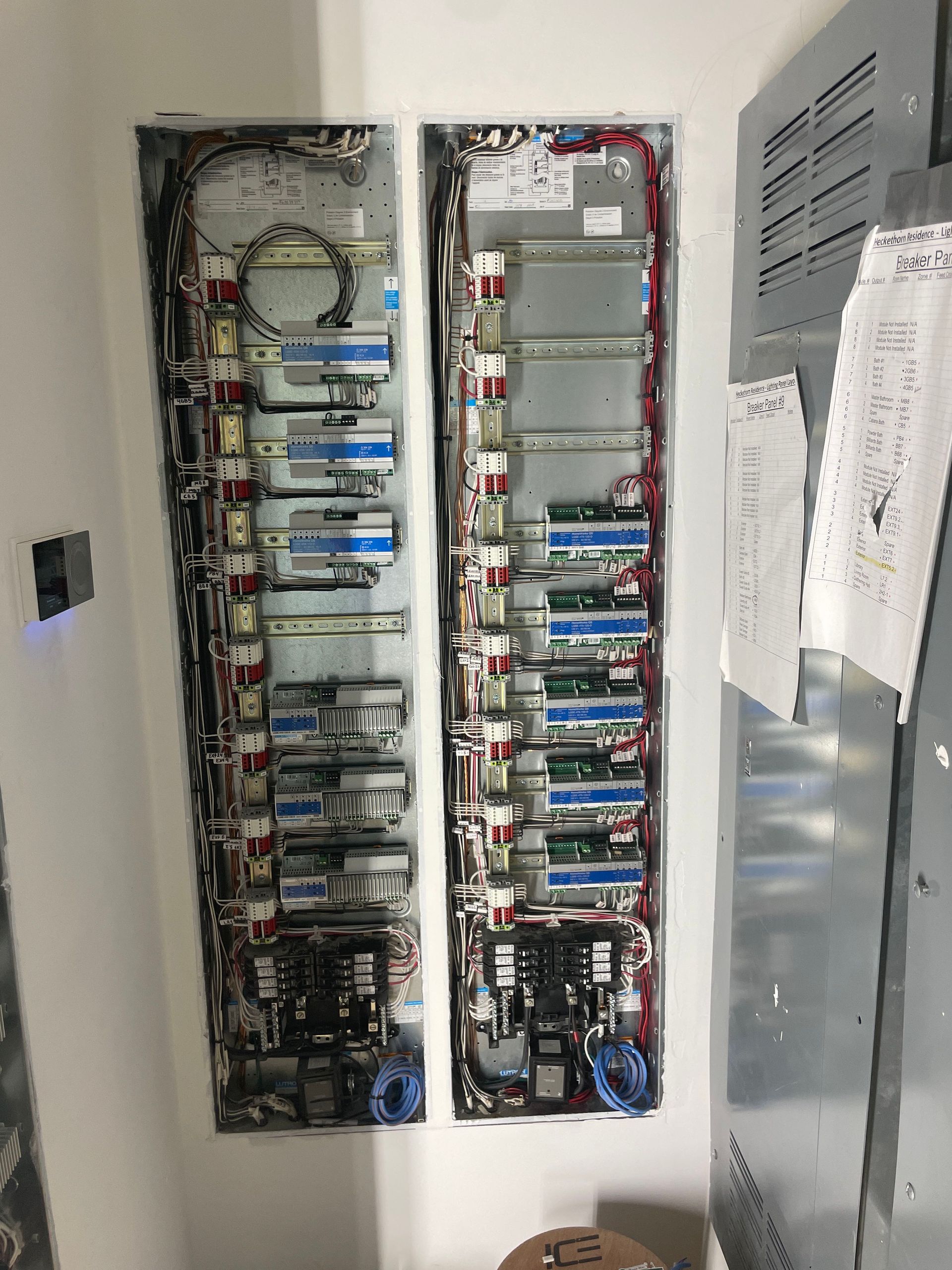 Two electrical panels are sitting next to each other on a wall.