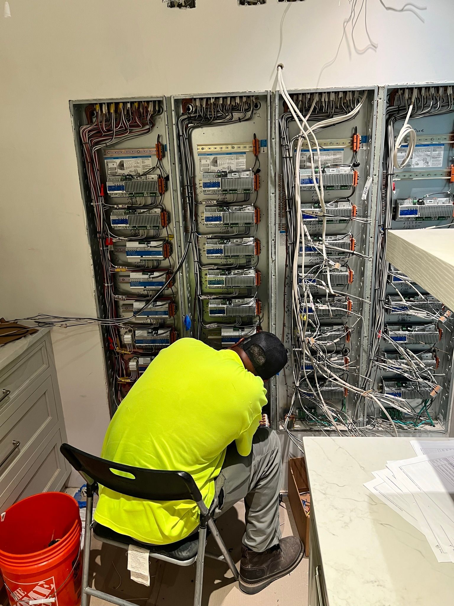 A man in a yellow shirt is working on a server.