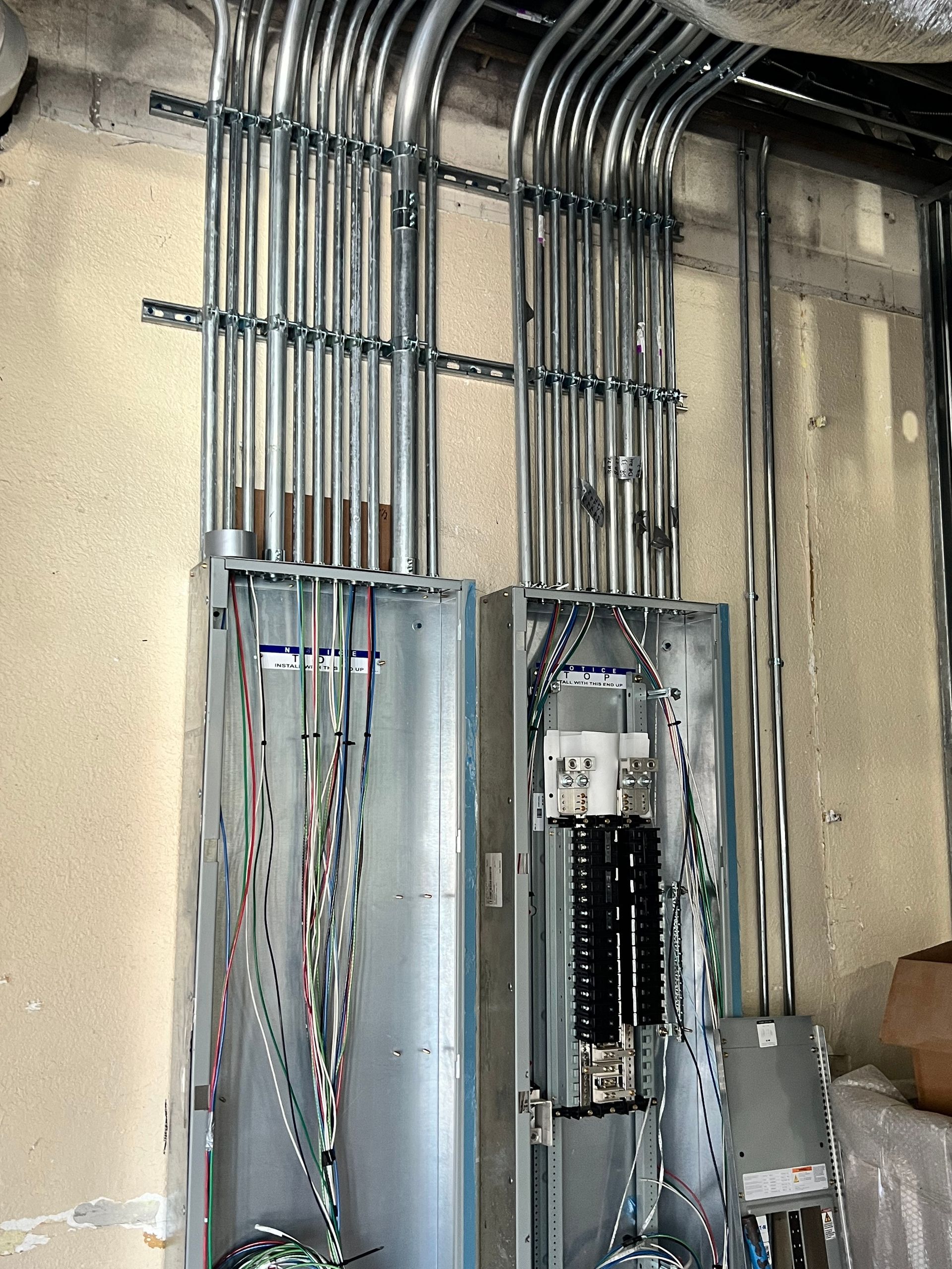 A bunch of electrical wires are hanging from a wall