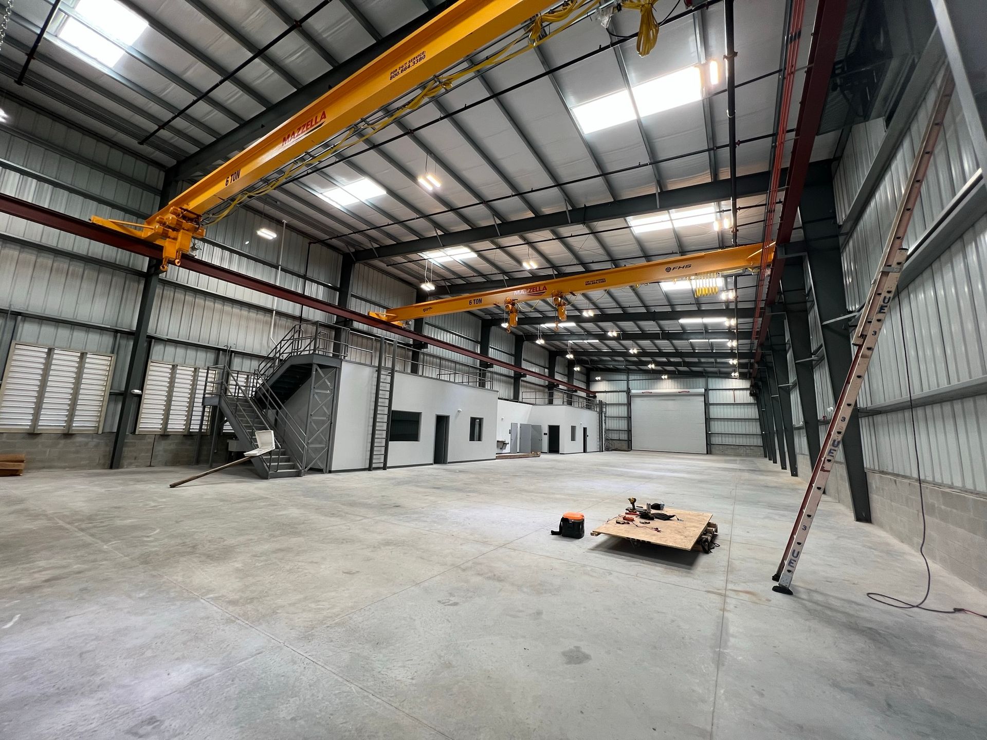 A large warehouse with a crane in the middle of it