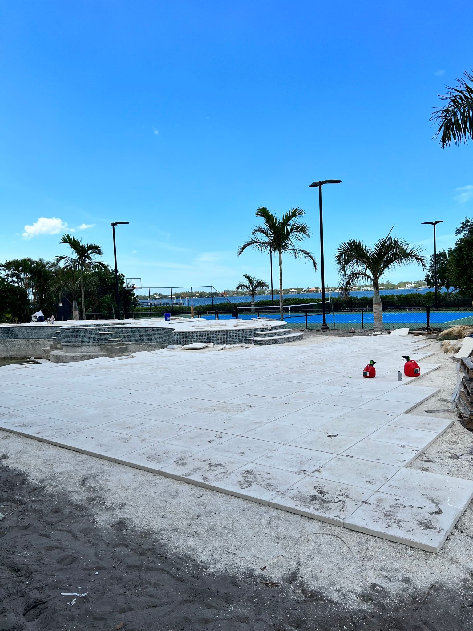 A large white sandy area with palm trees in the background