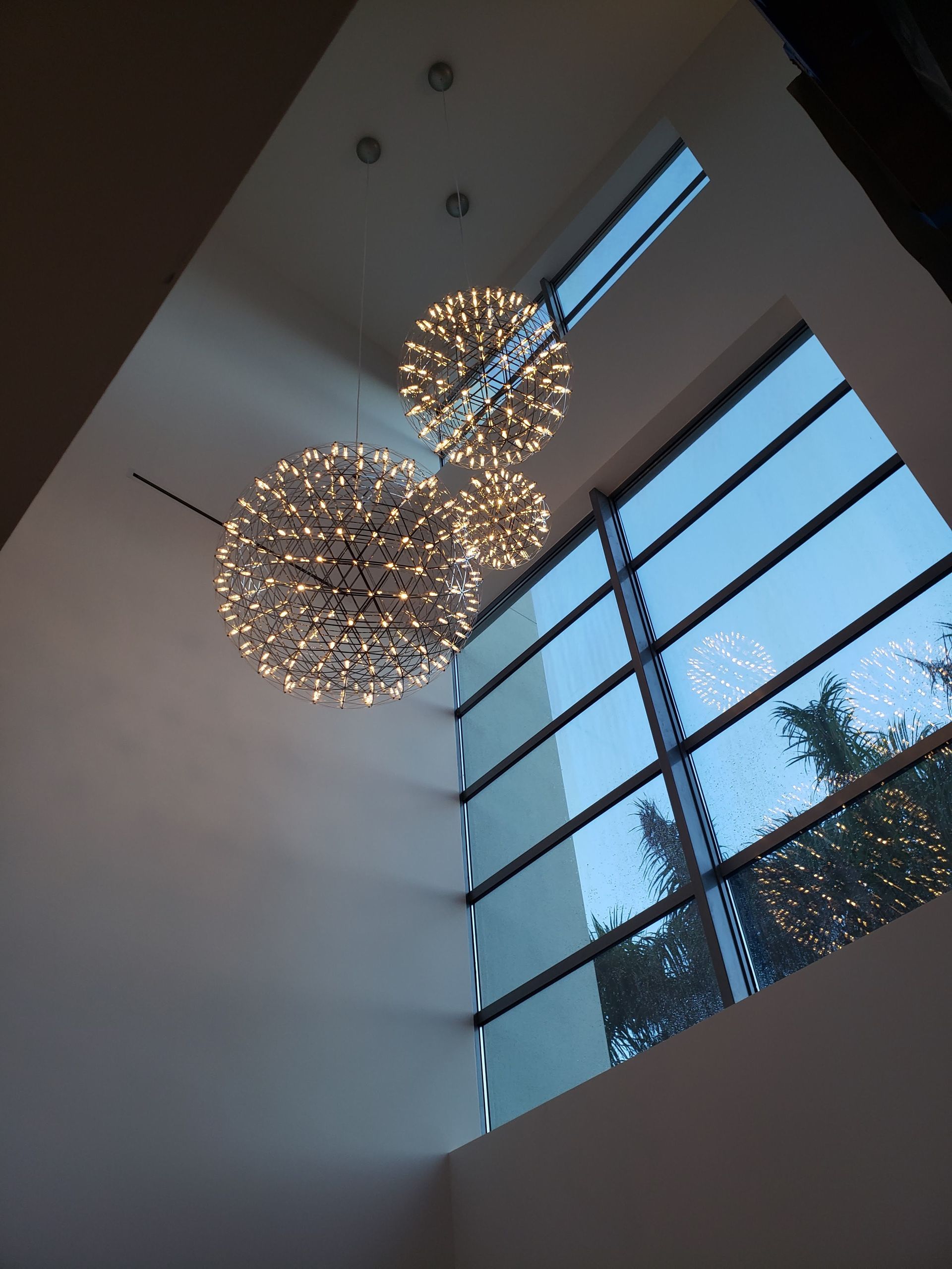 A large window with a few lights hanging from the ceiling