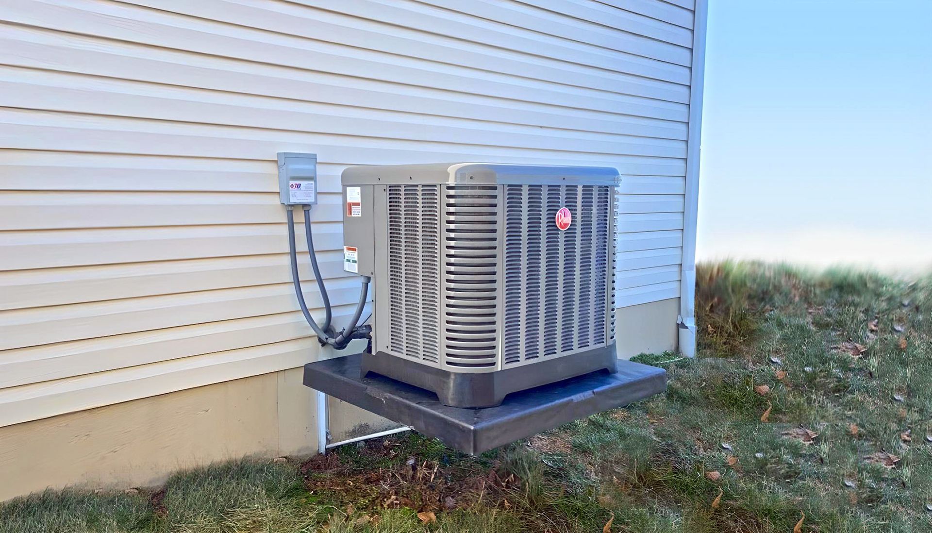 Air conditioning unit on a black base, next to a white house