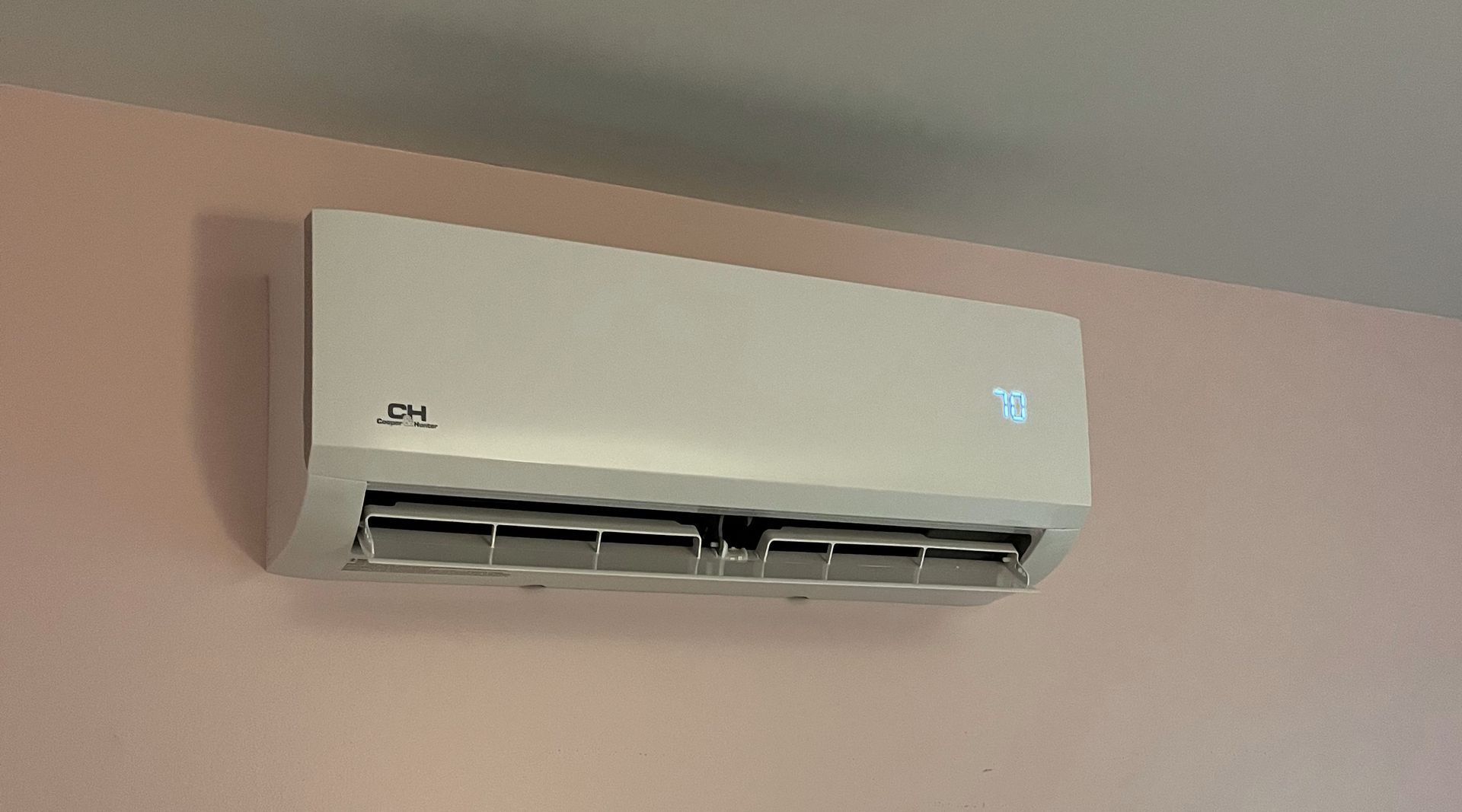 Split-type AC on a pink wall
