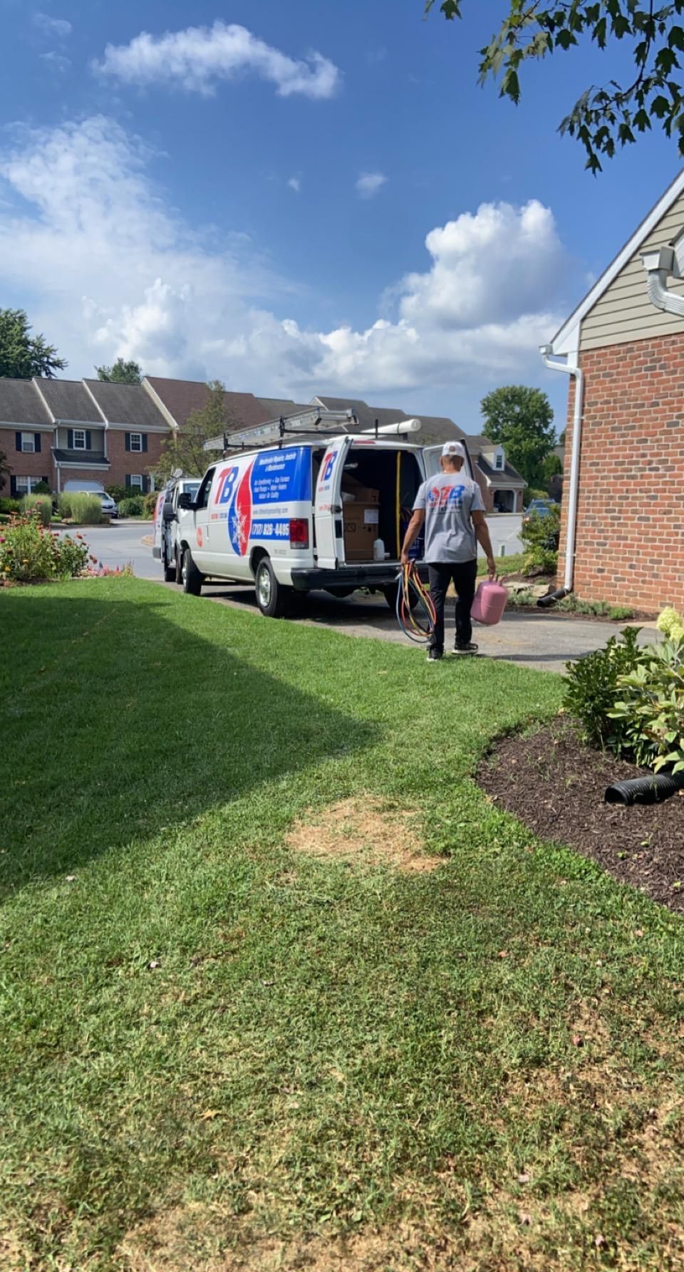 A man is walking towards a van parked in front of a house.