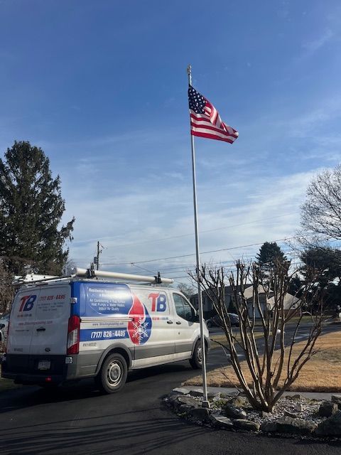 A tb van is parked in front of an American flag.