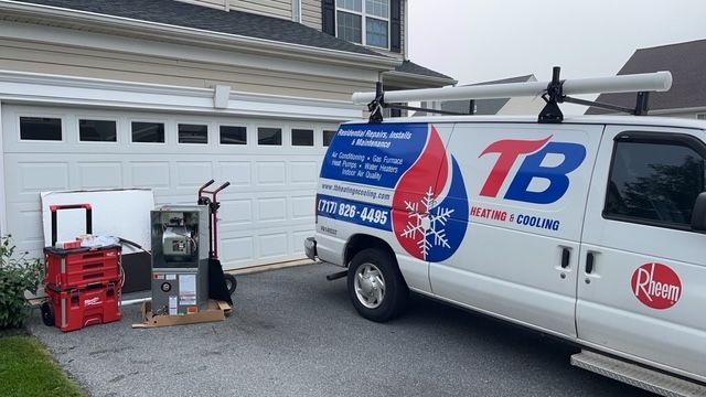 A tb van is parked in front of a garage door.