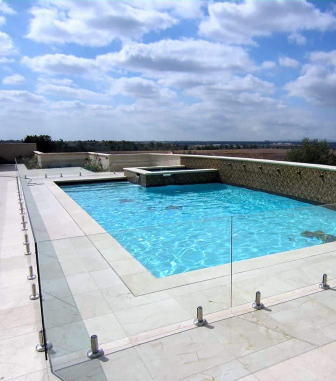 a large swimming pool with a glass fence around it.