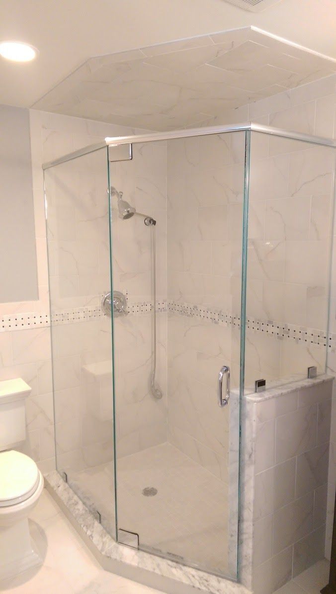 a bathroom with a toilet and a shower with a glass door.