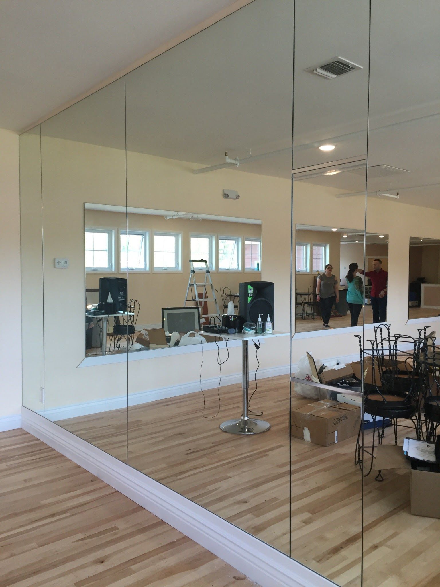 a large mirror in a room with a wooden floor.