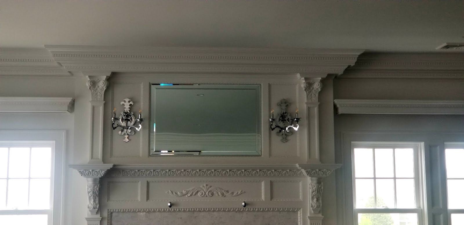 a living room with a fireplace and a mirror on the wall.