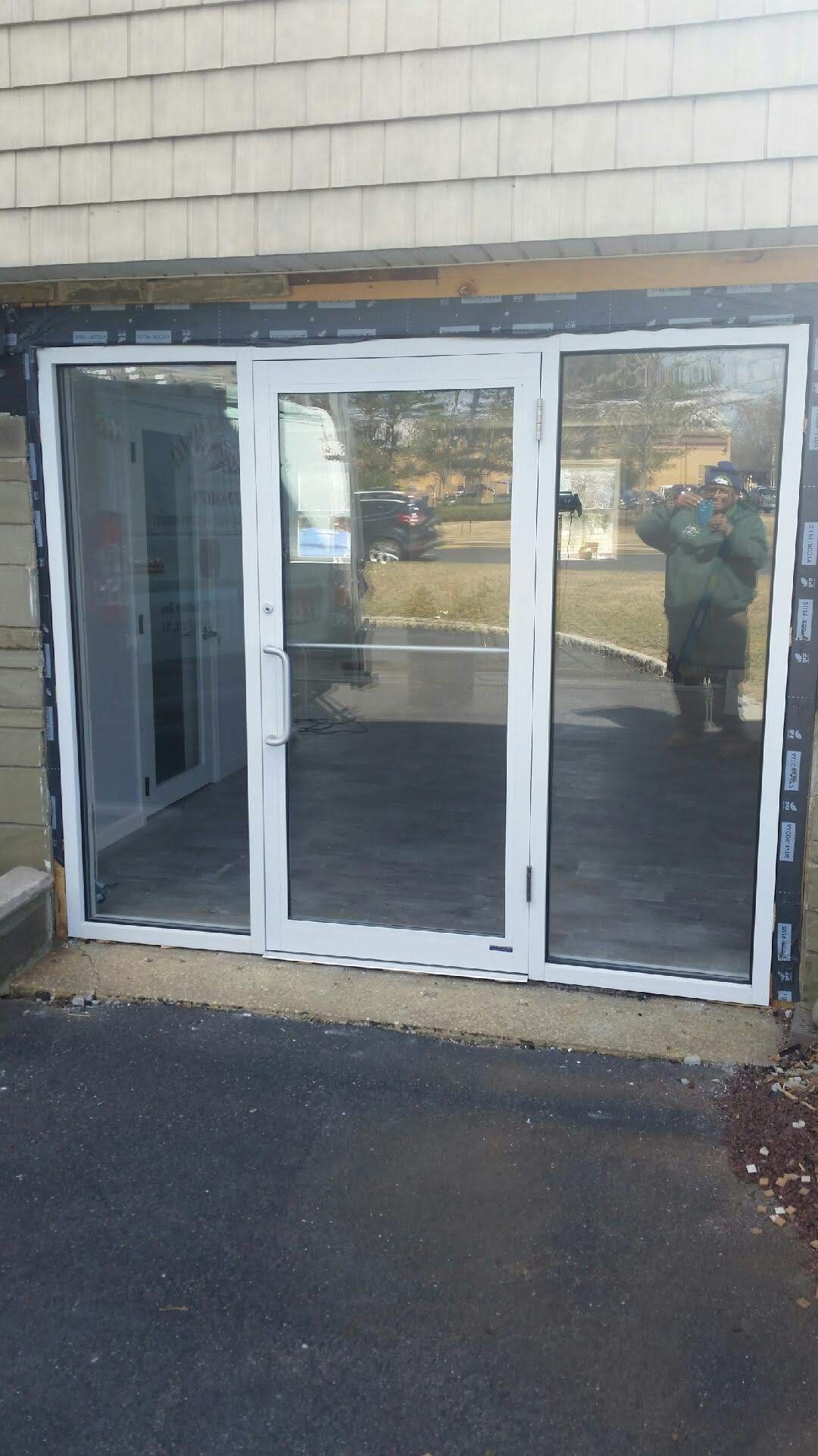 a man is standing in front of a large glass door.