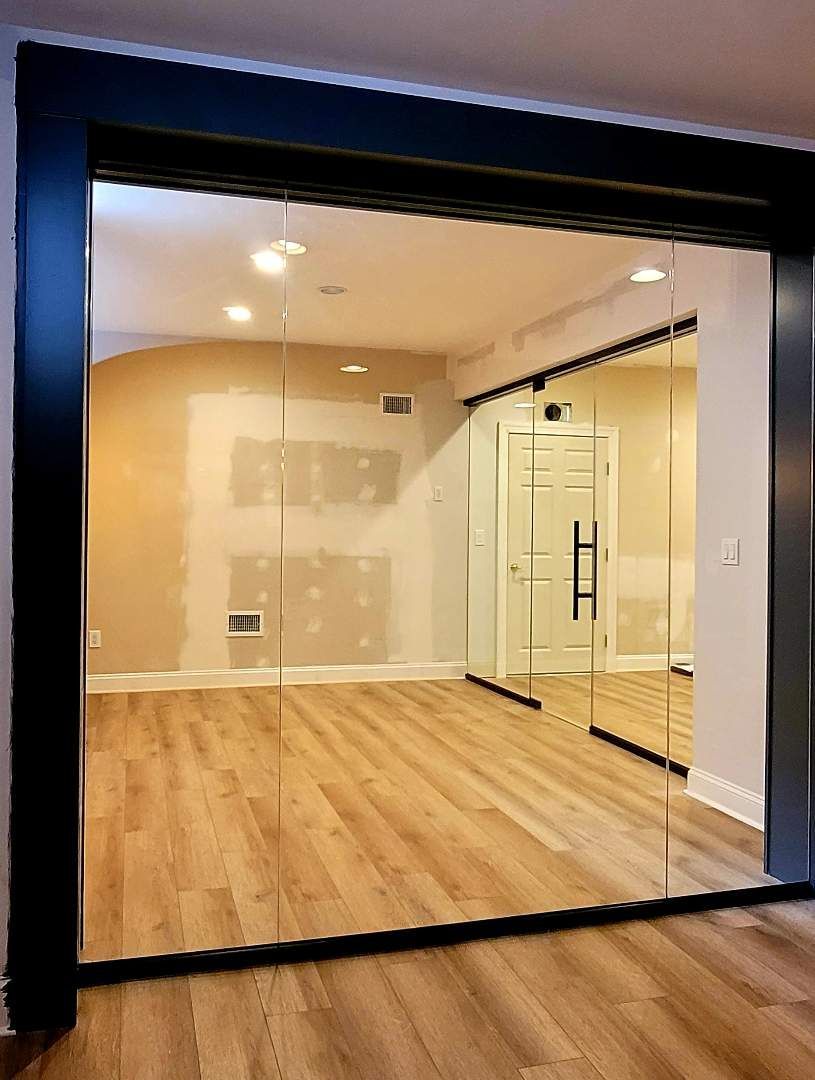 a room with a lot of glass doors and a wooden floor.