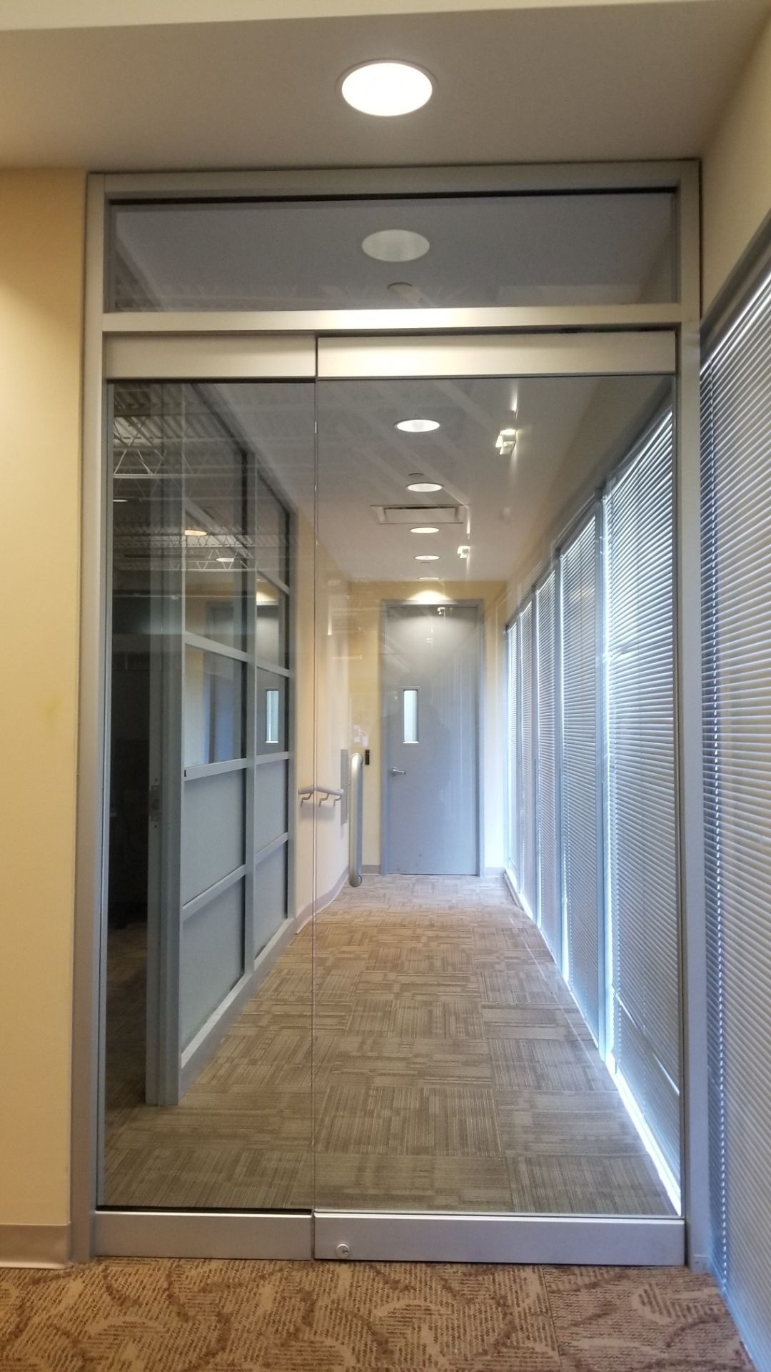 a long hallway with sliding glass doors and blinds.